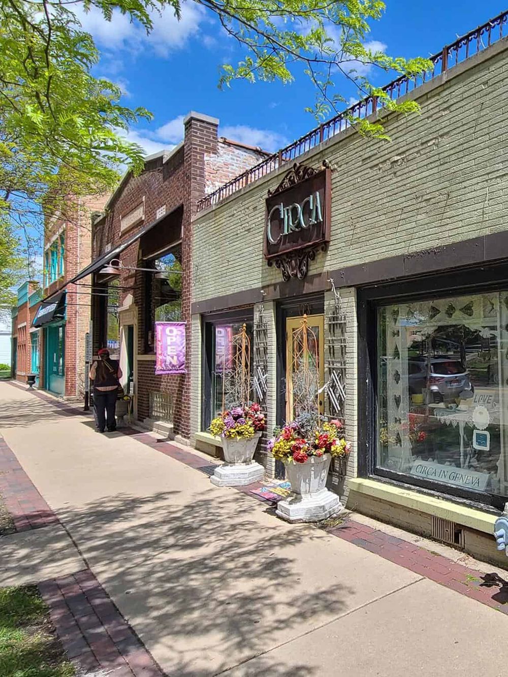 Charming boutique storefront on a sidewalk in Geneva with floral displays and vintage-inspired signage.