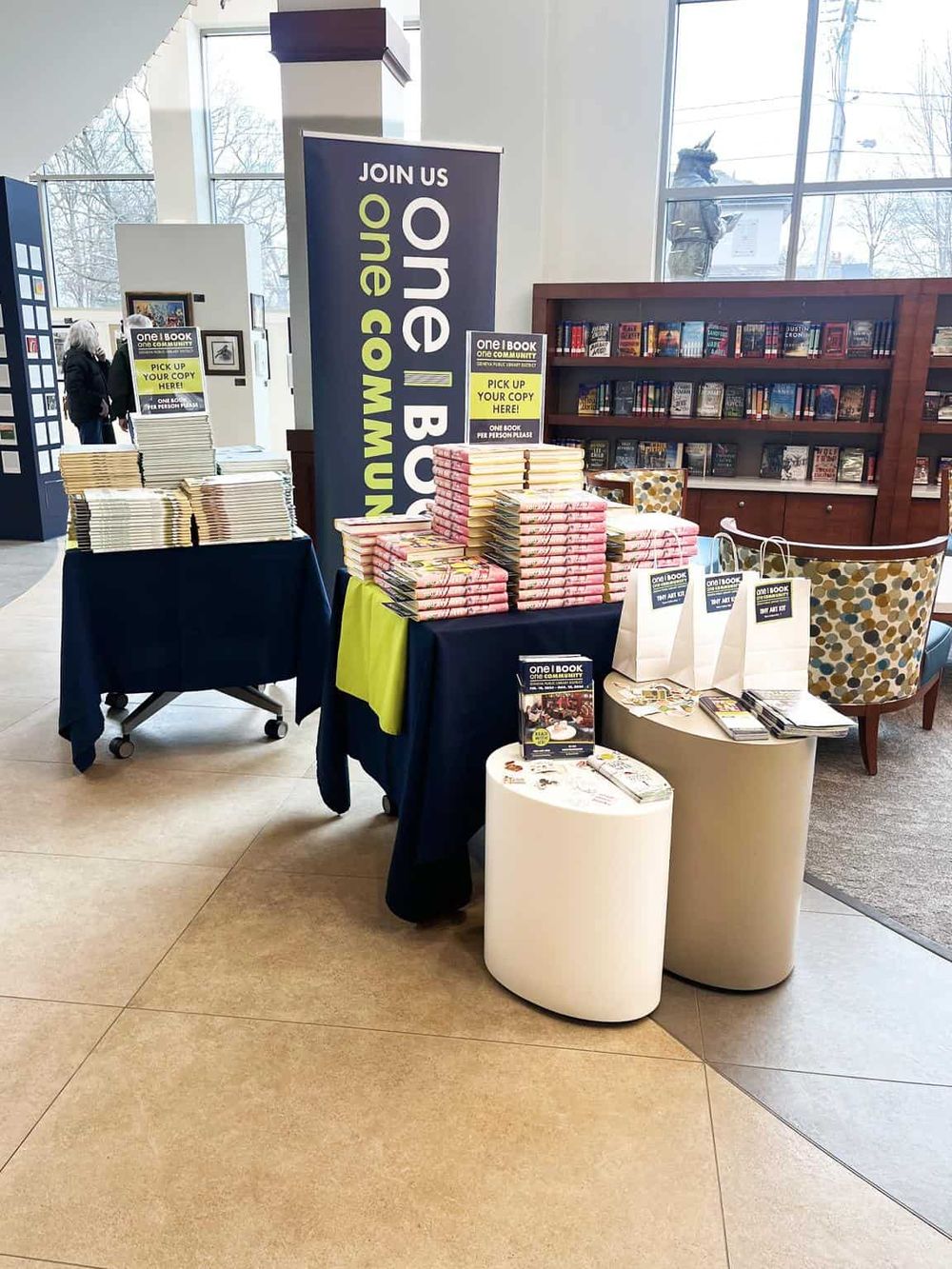 Bookshelf and promotional display for QuestForDirections inside a bookstore or library, featuring community books, signs, and promotional materials.