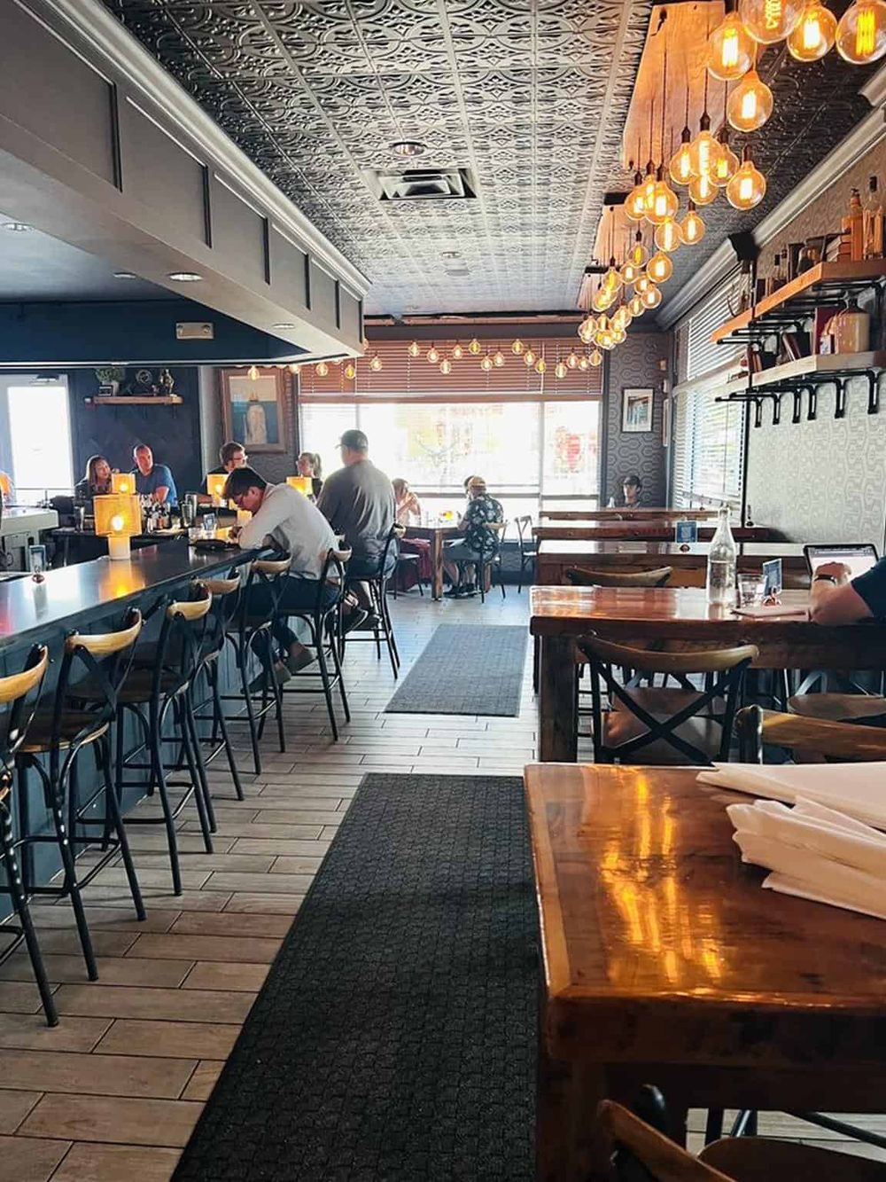 Cozy modern restaurant interior with stylish lighting and wood accents, perfect for dining and socializing.