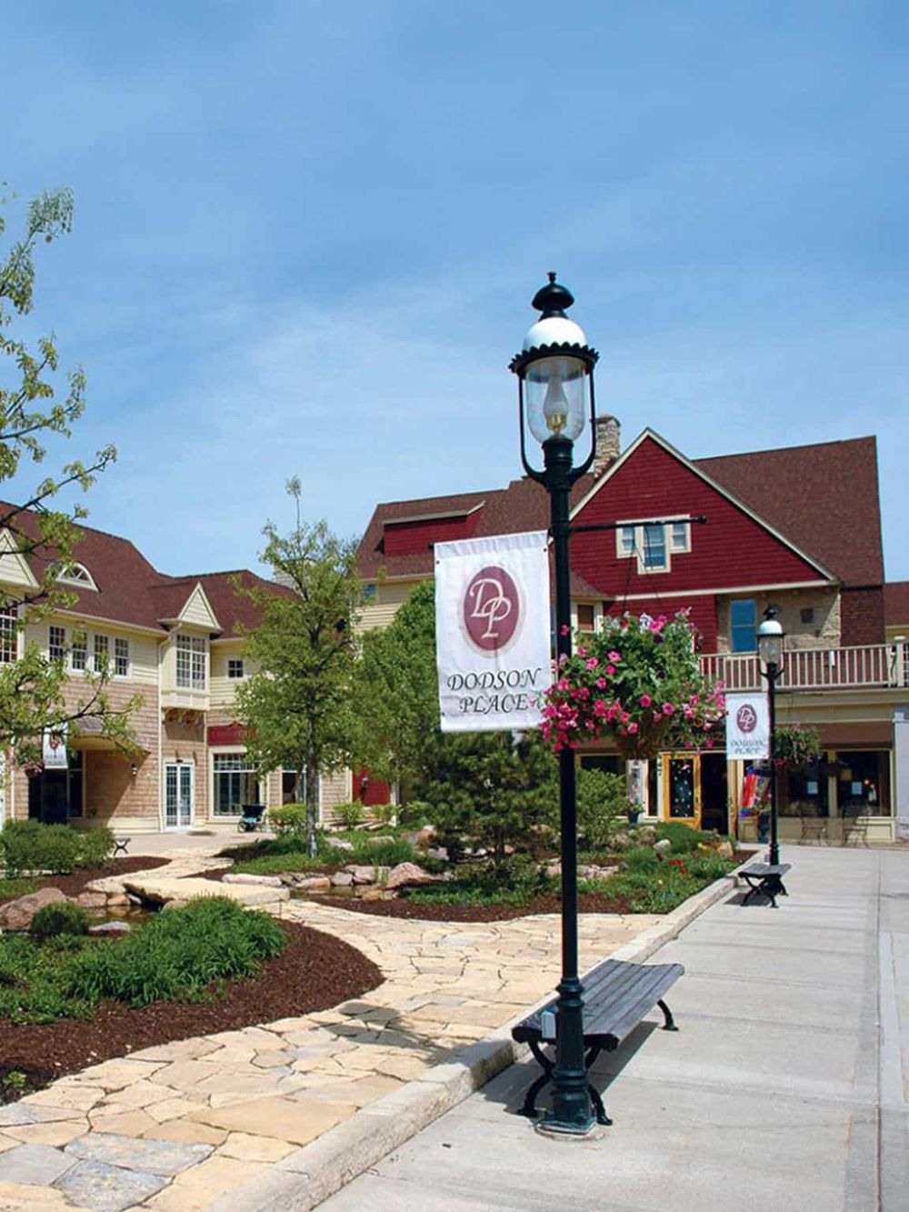 Charming shopping center with outdoor seating, lampposts, and vibrant greenery, perfect for local shopping and dining.