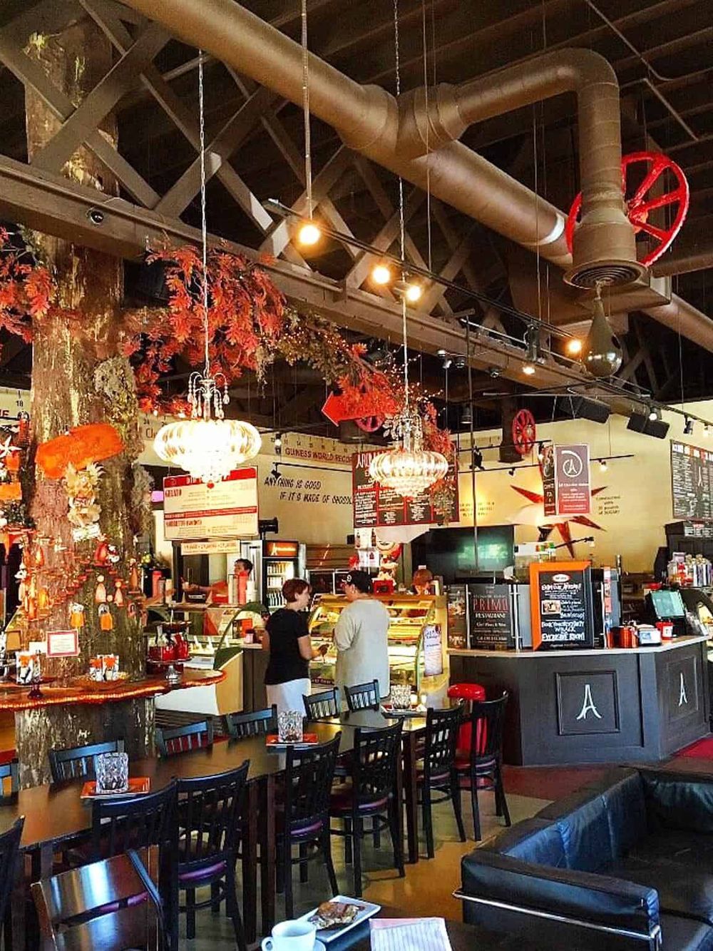 Vibrant café interior with autumn décor, modern lighting, and cozy seating for dining and socializing.