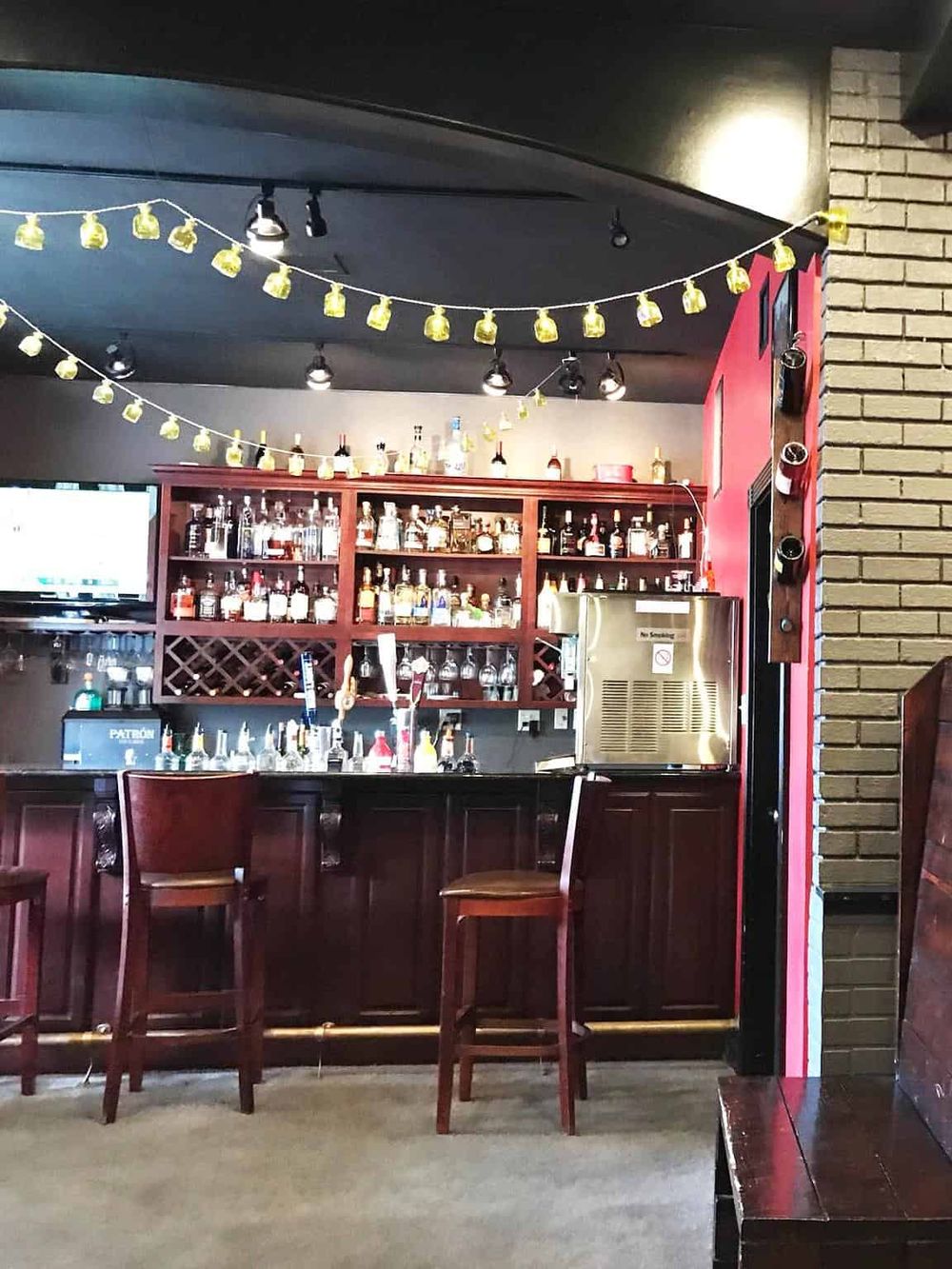 Bright bar interior with liquor shelves, string lights, and cozy seating at QuestForDirections.