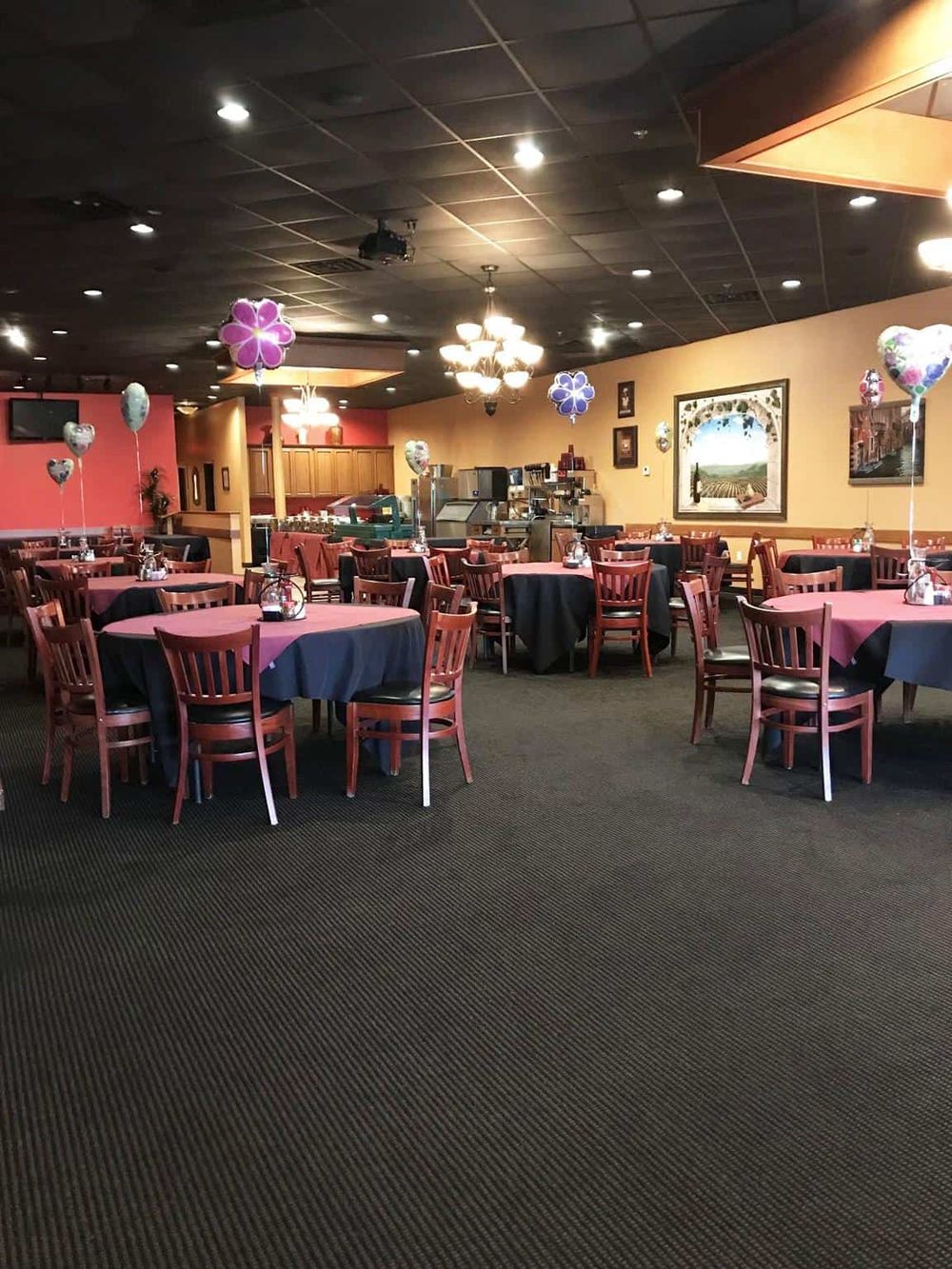 Colorful decorated dining area with balloons, tables, and chairs at QuestForDirections event space.