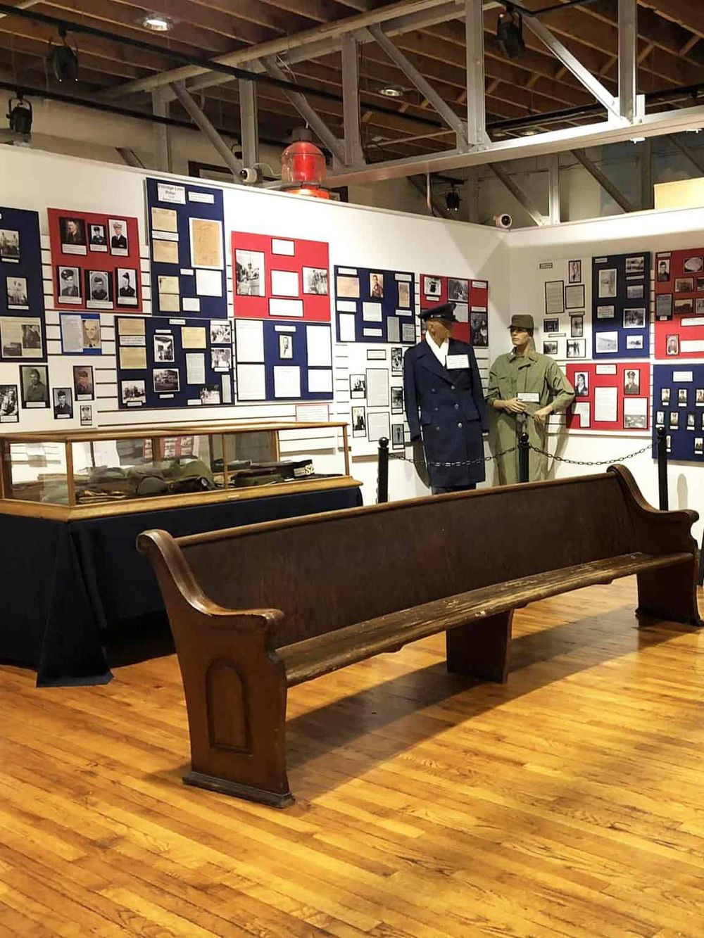 Historic military display at QuestForDirections museum showcasing WWII uniforms and archival photos.