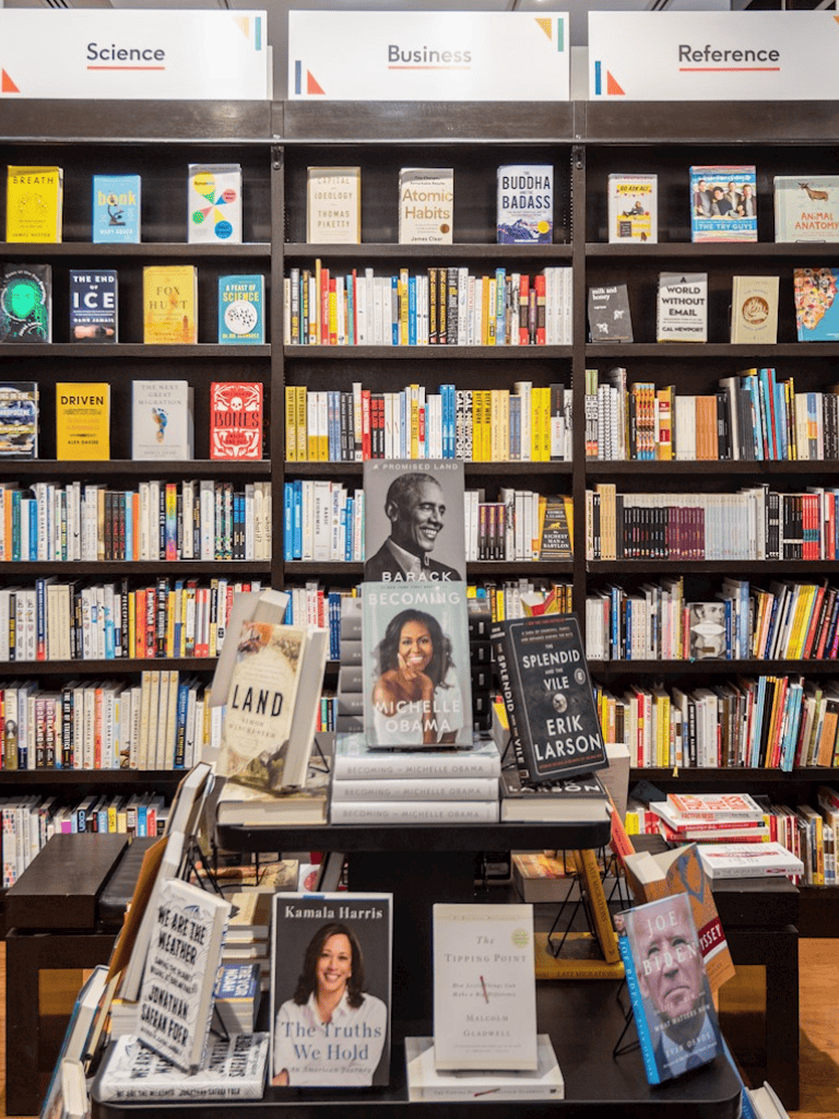 Thoughtful bookshelf display featuring popular books on science, business, and reference topics in a bookstore setting.