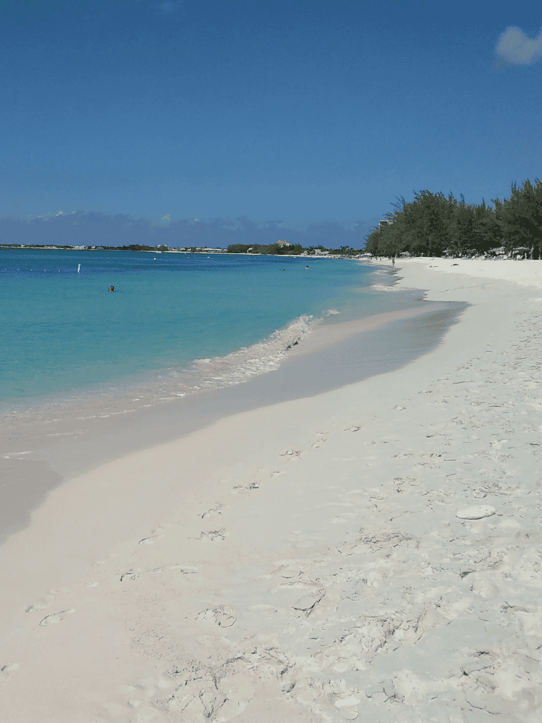 Peaceful beach with white sand and turquoise water, ideal for relaxing vacations and water activities.