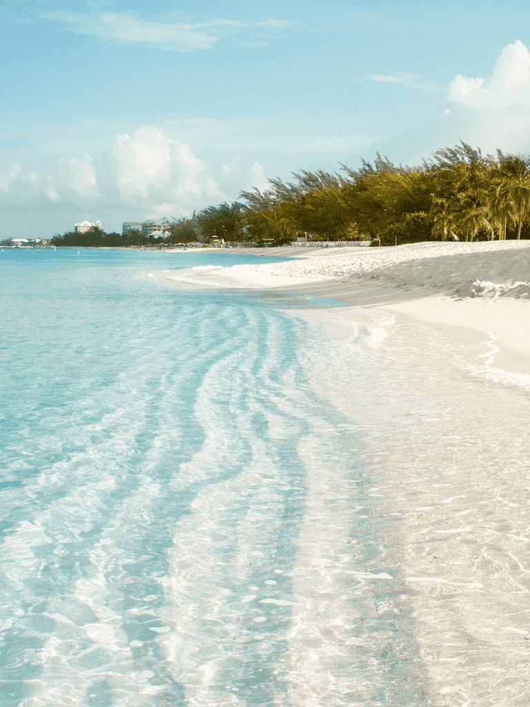 Pristine Caribbean beach with clear turquoise waters and white sandy shoreline.