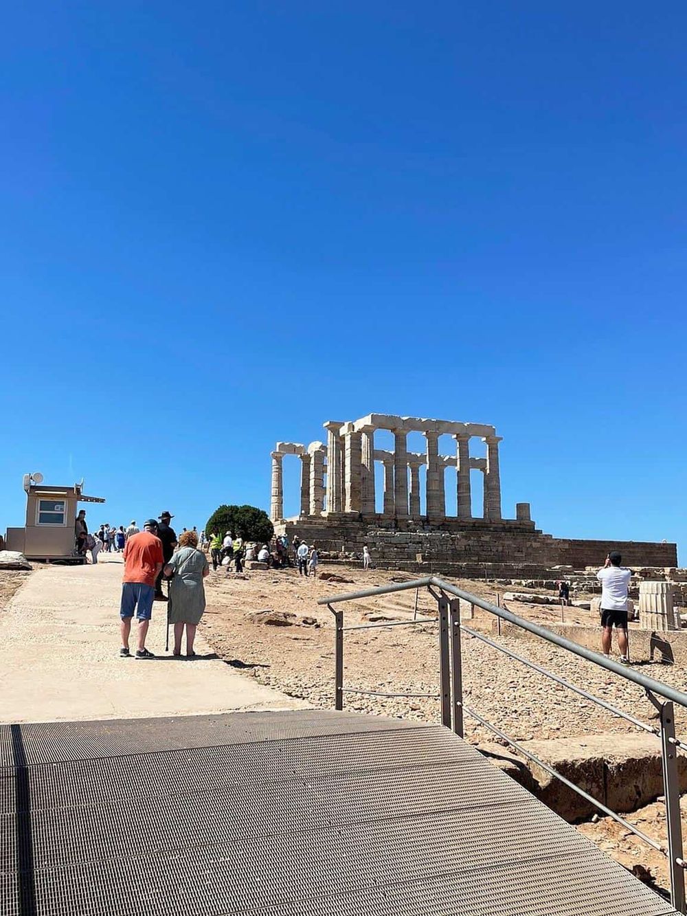 Ancient Greek Parthenon ruins featuring iconic columns and tourists at the historical site.