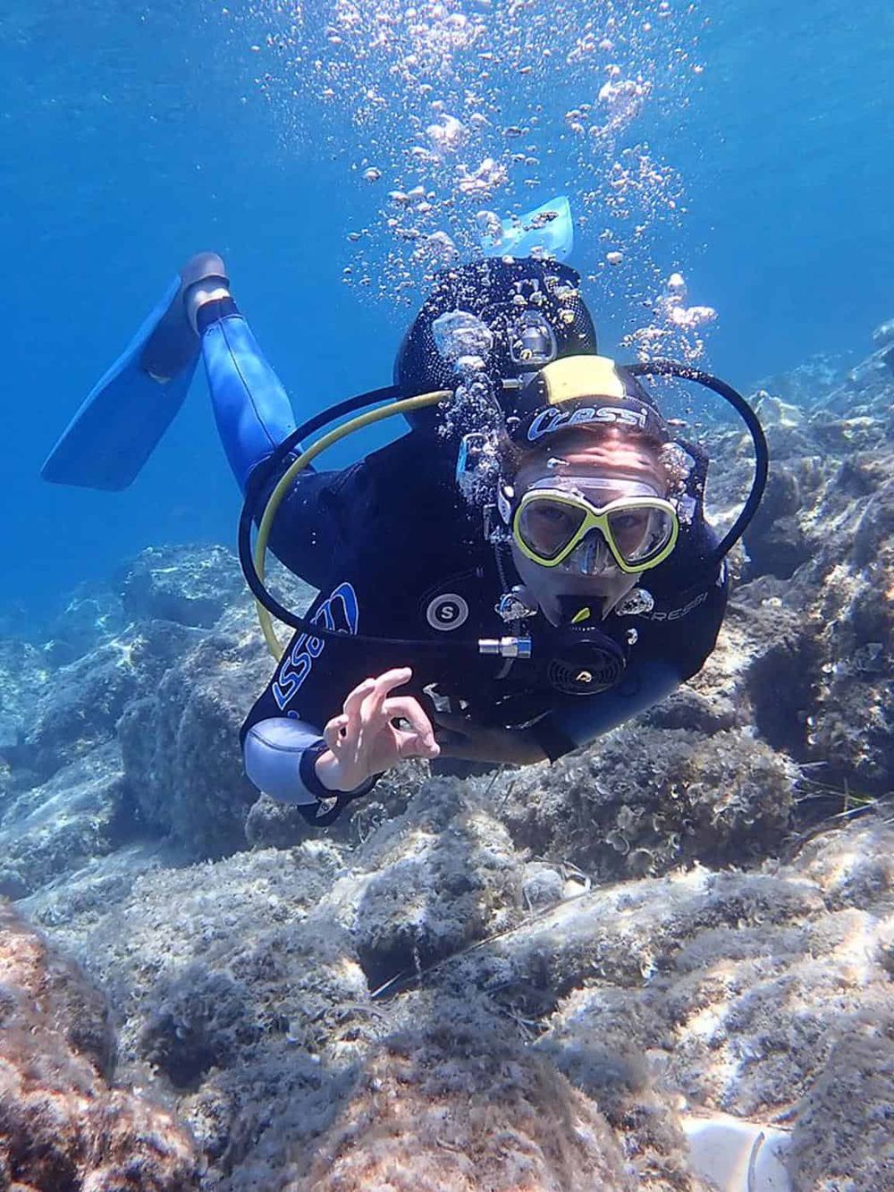 Scuba diver exploring vibrant coral reef and marine life underwater.