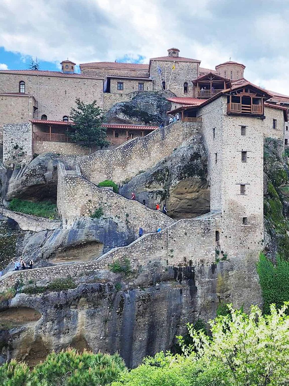 Ancient Greek monastery built on rocky cliffs, revealing historical architecture and scenic views.