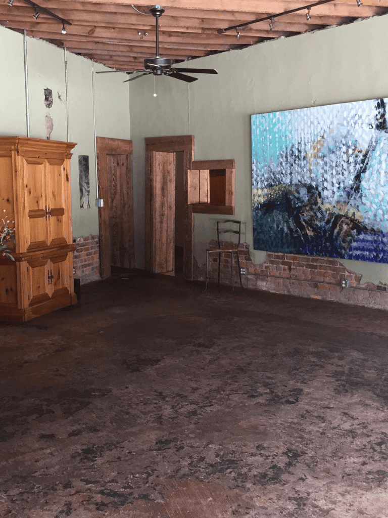 Rustic interior with exposed brick, wooden accents, and abstract wall art for creative workspace or gallery.