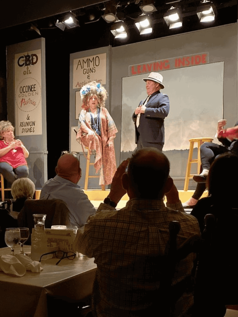 Clown performer with colorful wig on stage during comedic show at QuestForDirections event.