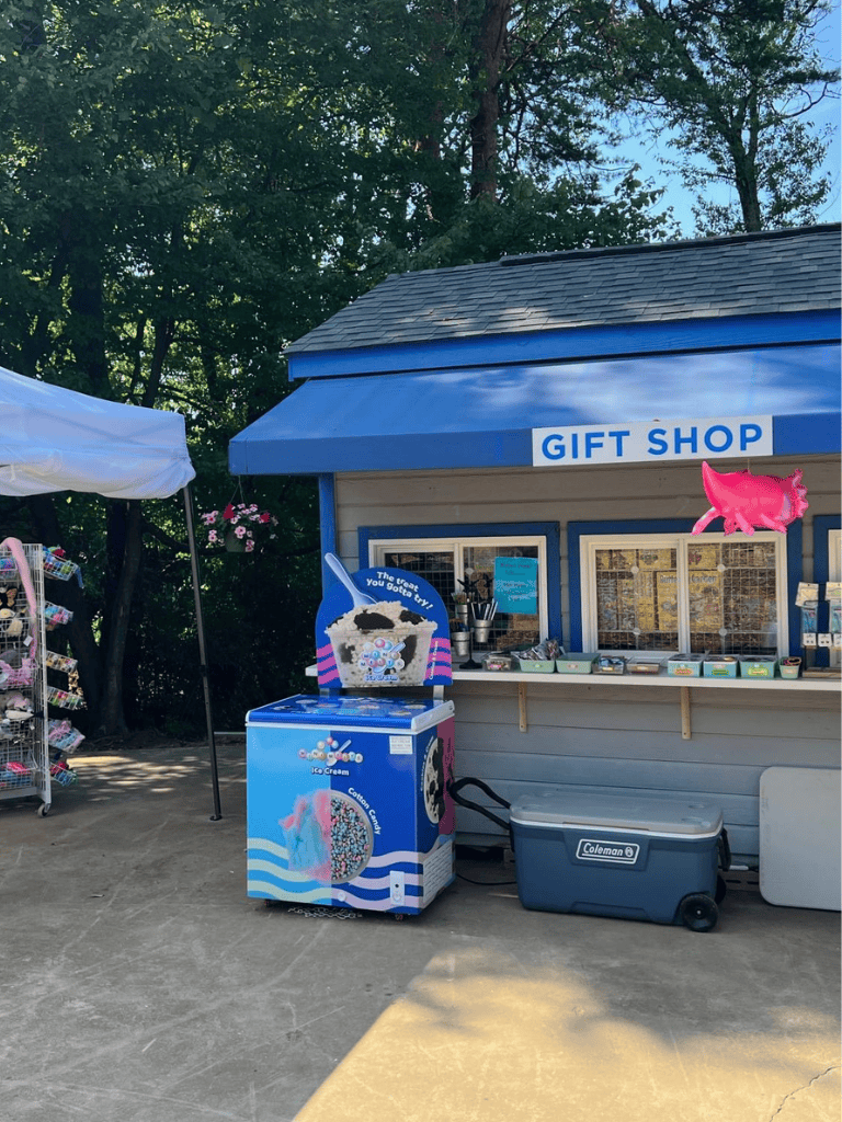 Colorful gift shop with ice cream freezer and outdoor merchandise stand at QuestForDirections.