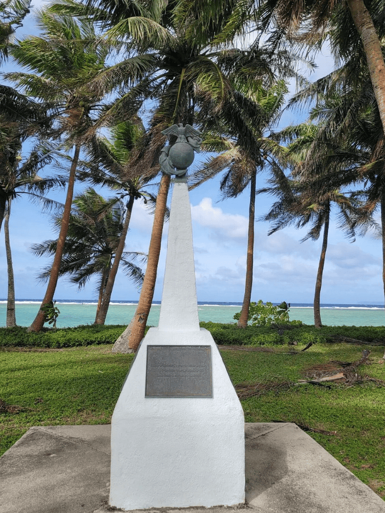 Cloth and Stone Memorial with palm trees and ocean in the background, representing a tropical coastal landmark.