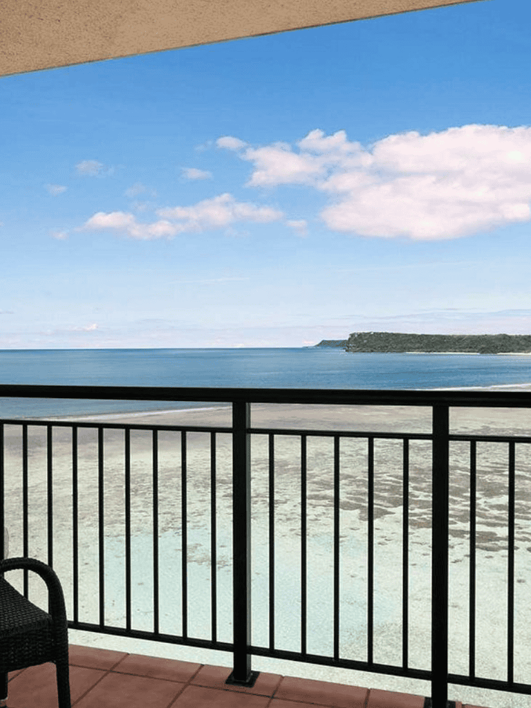 Breathtaking ocean view from balcony showcasing scenic coastline and blue sky, perfect for travel inspiration.