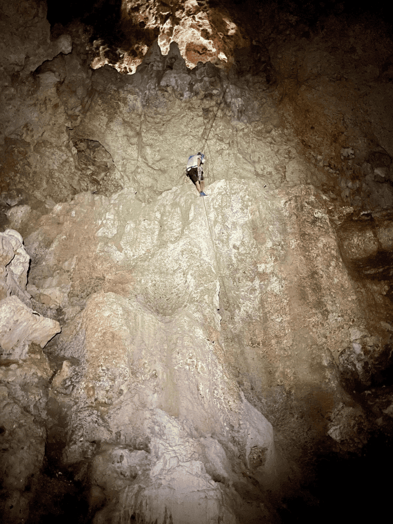 Abseiling in a dark cave for adventure and exploration.