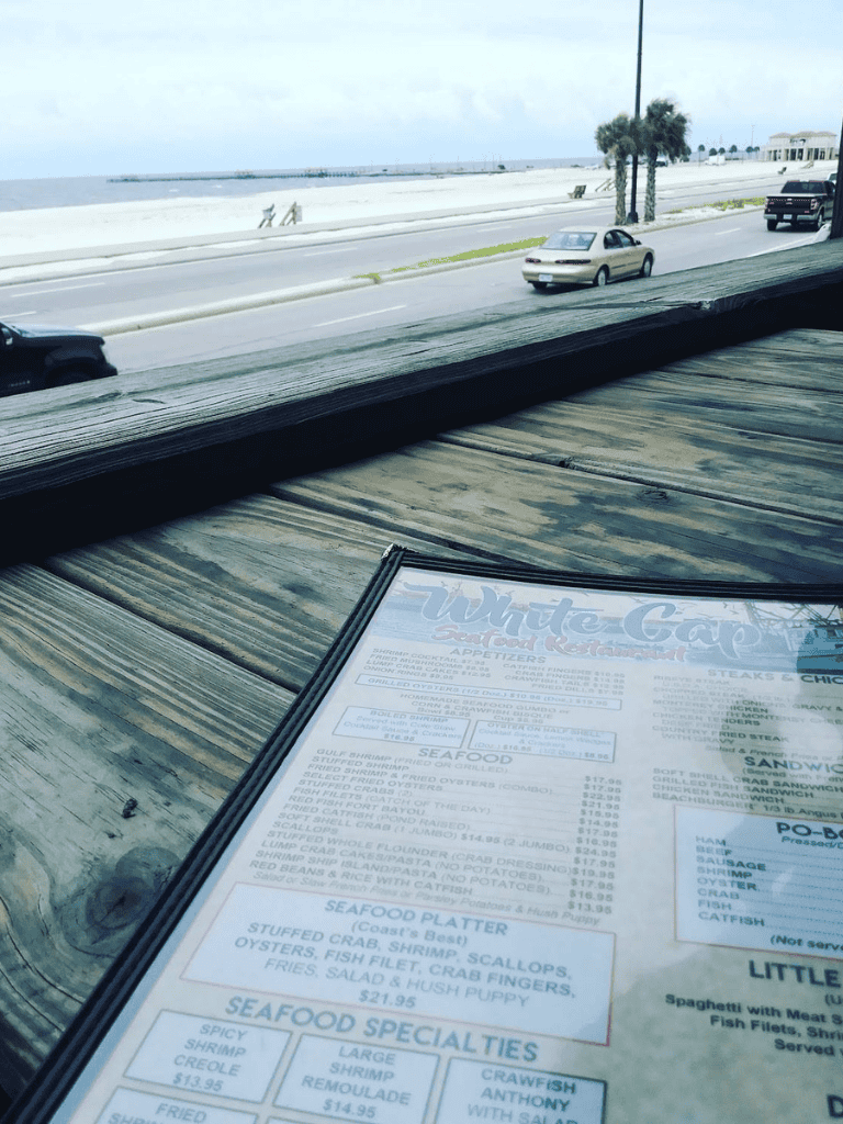 1. Ocean view seaside restaurant with outdoor seating and beach access.