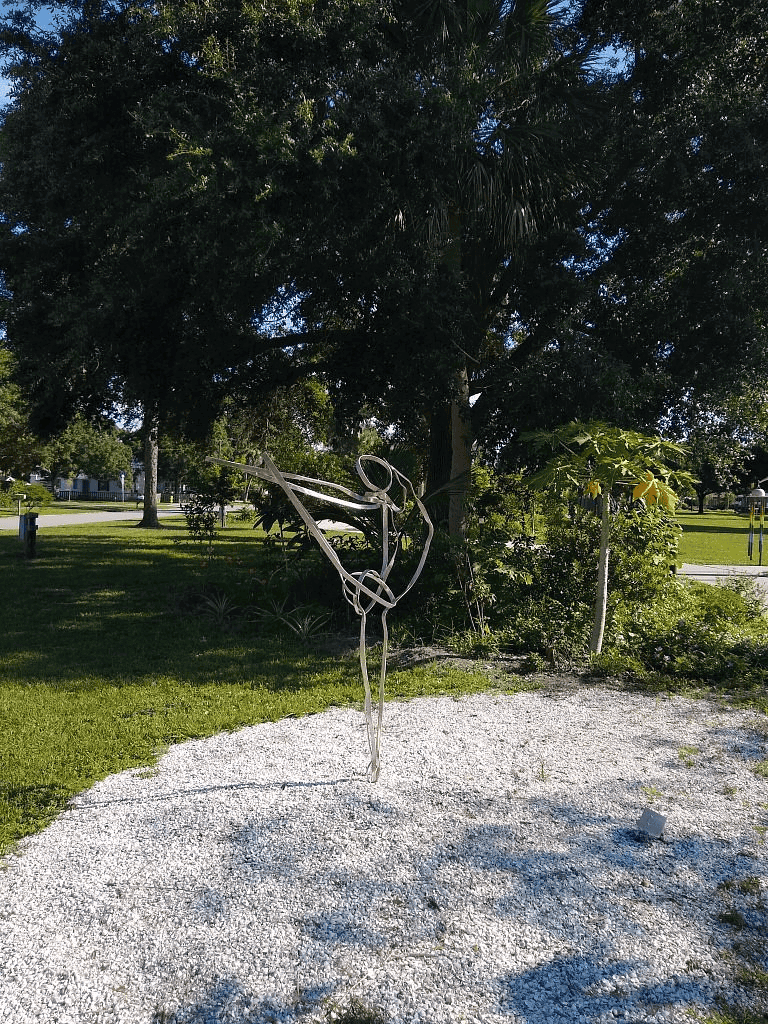 Aerial silks sculpture art in park, outdoor modern sculpture, ballet dancer art, public park decor, abstract dance artwork.