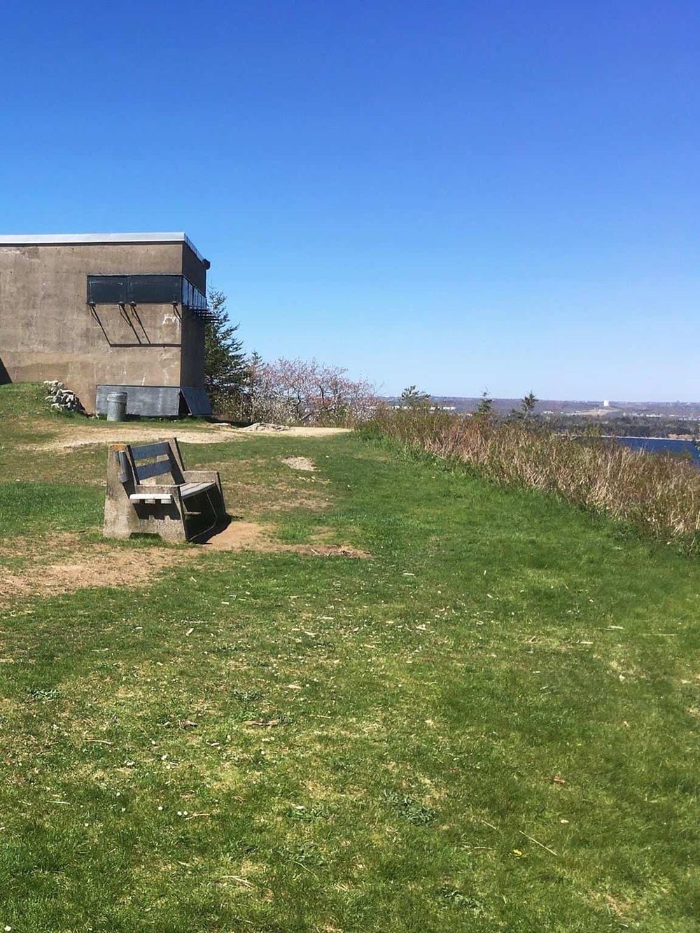 Scenic outdoor view with benches, grassy area, and clear blue sky, perfect for relaxing and finding directions.