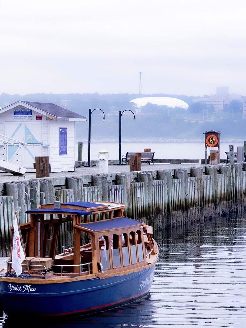 Picturesque waterfront scene with boat dock, wooden pier, and misty cityscape background, showcasing QuestForDirections' navigation services.