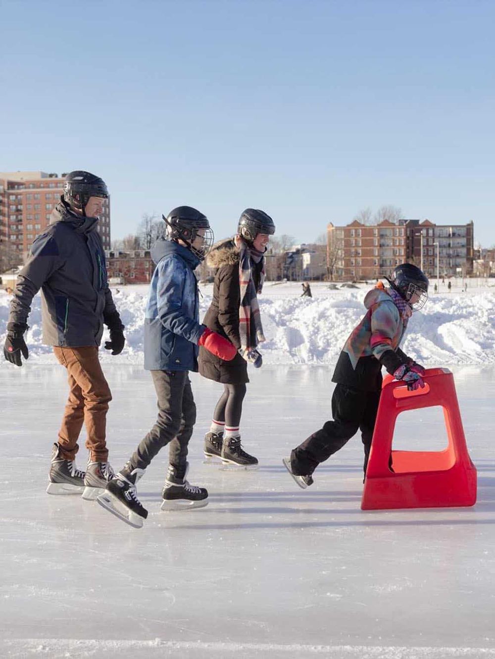 Children ice skating in winter sports activity on an outdoor rink, enjoying fun and fitness.