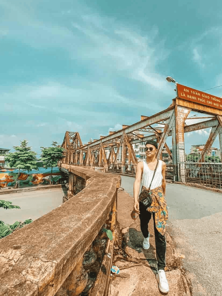 Vibrant city bridge with young woman walking, urban landscape, and blue sky background.