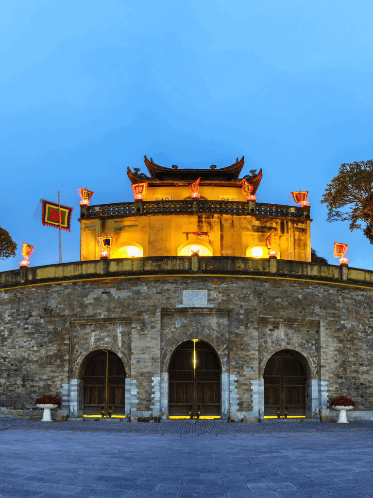 Vientiane Patuxai Victory Monument at dusk, lit up and showcasing traditional Lao architecture.