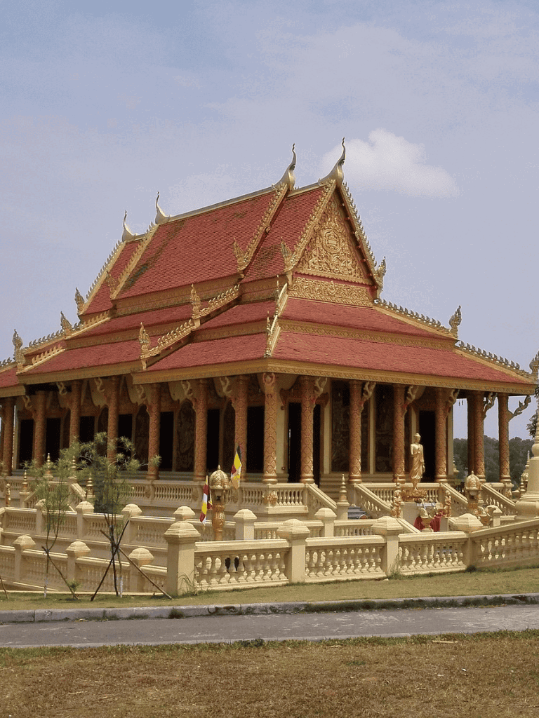 Intricate traditional Thai temple with red-tiled roof and ornate golden details.