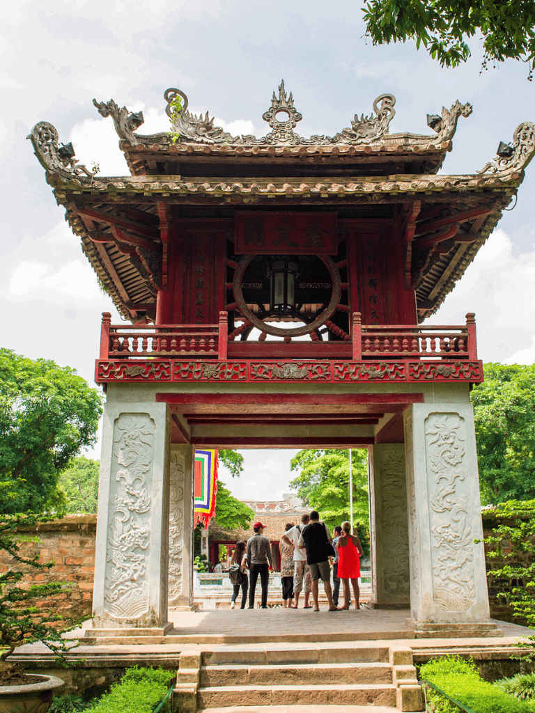 Ancient Vietnamese temple gate with intricate carvings and vibrant red colors.