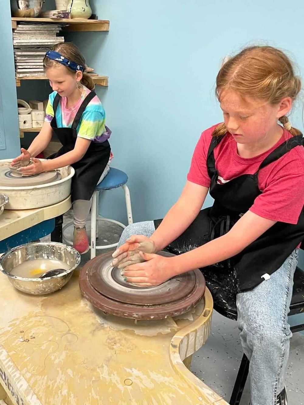 Clay pottery making by children at a pottery studio.