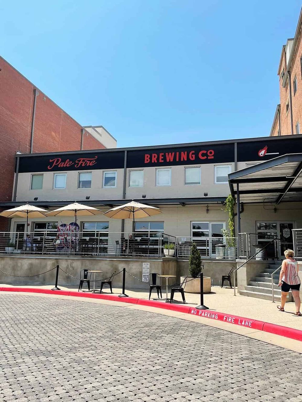 Modern brewery with outdoor seating and vibrant signage for Pale Fire Brewing Co.