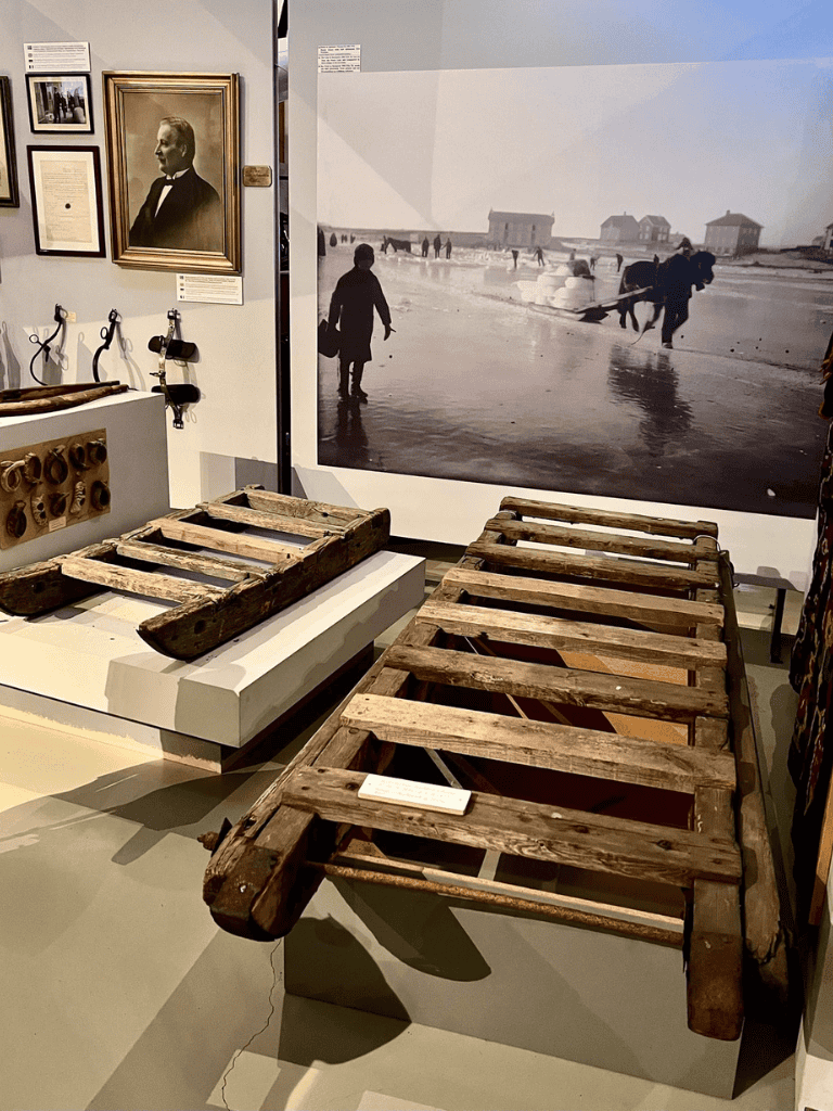 Rustic wooden sled display at QuestForDirections museum exhibit.
