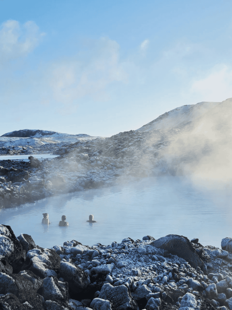 Steam geothermal hot springs surrounded by snowy rocky landscape in Iceland.