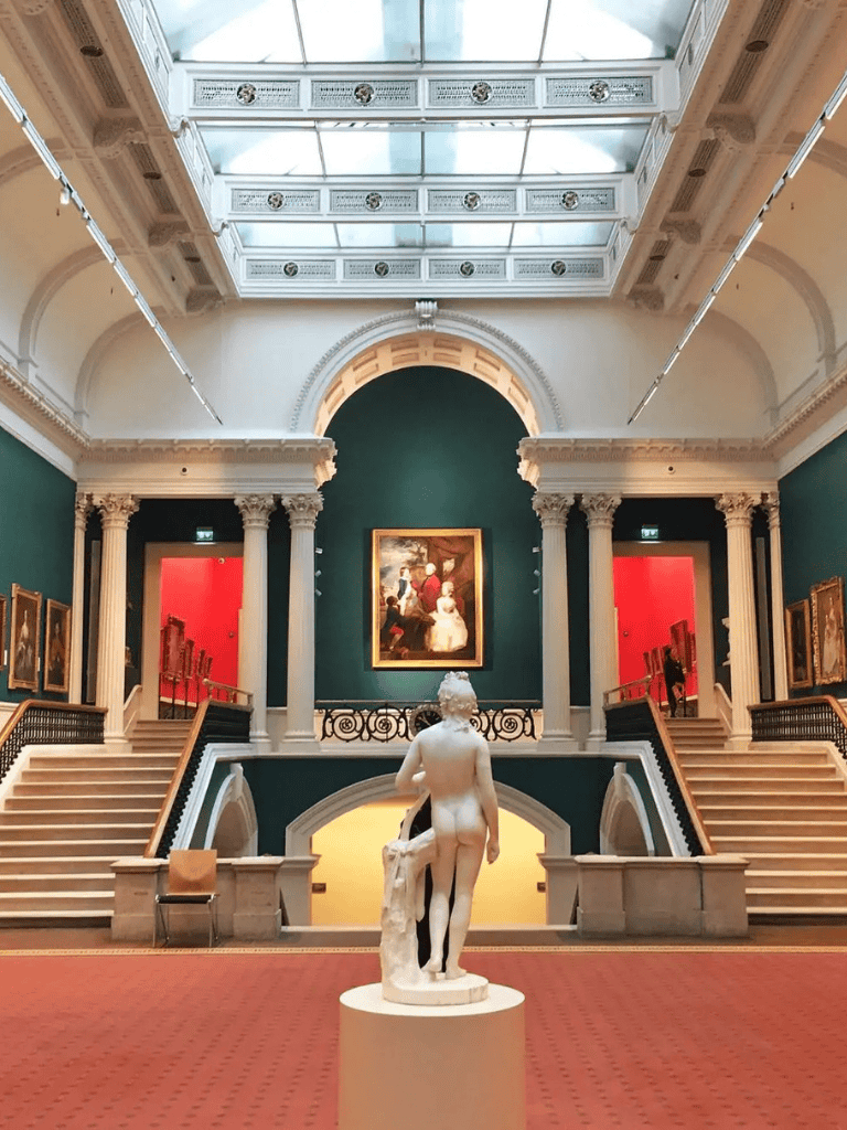 Elegant art museum interior with classical sculpture and ornate architectural details.
