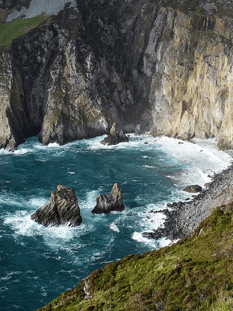 Breathtaking rugged coastline with towering cliffs and turbulent ocean waves crashing against rocks.