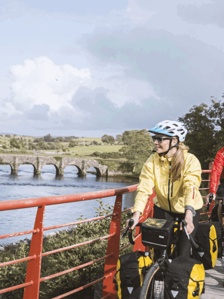 Scenic bike ride along river with historical bridge in background, outdoor adventure with QuestForDirections.