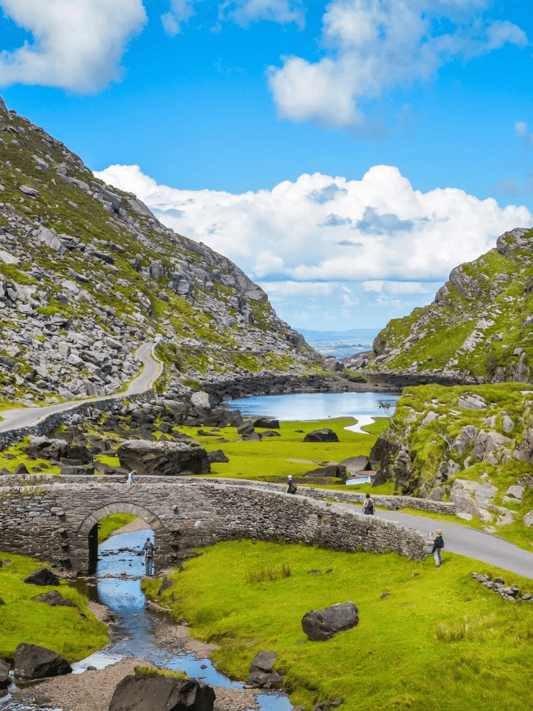 1. Scenic mountain landscape with stone bridge, lush green hills, and blue sky.