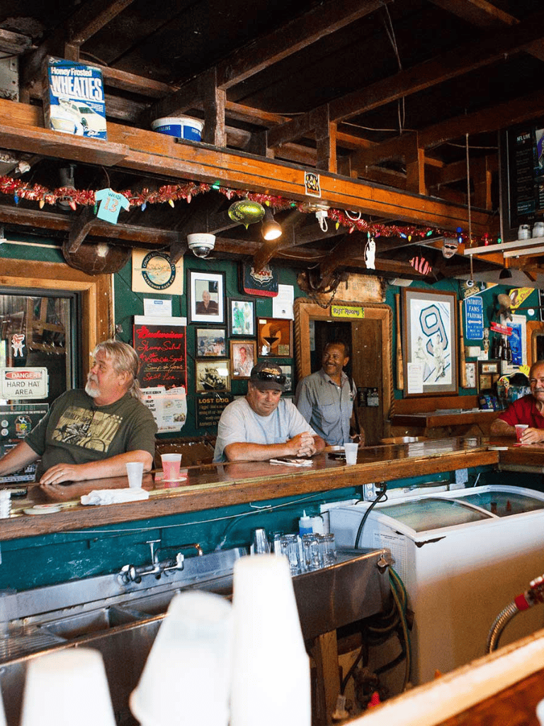 Cozy bar scene at QuestForDirections with patrons enjoying drinks in a rustic setting.