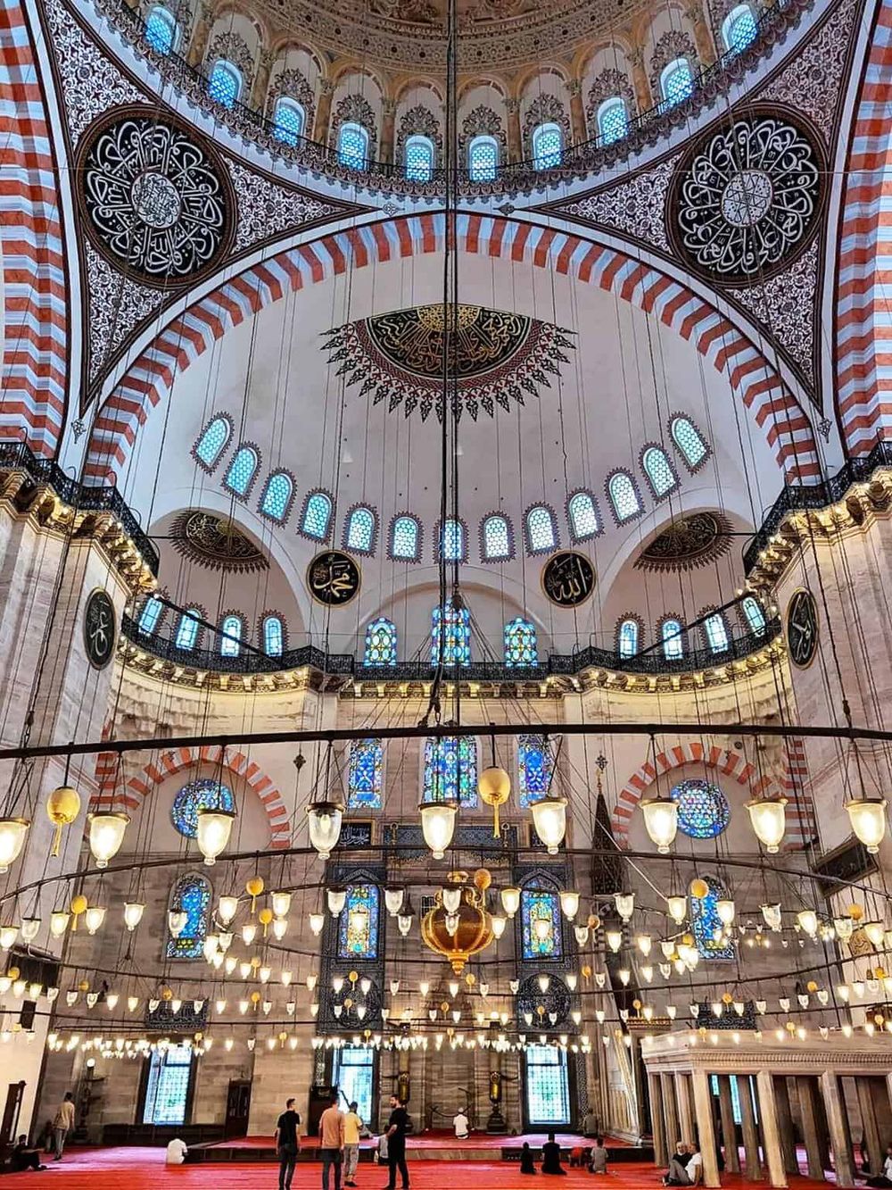 Intricately designed mosque interior with ornate architecture, stained glass windows, and traditional Islamic decorative elements.