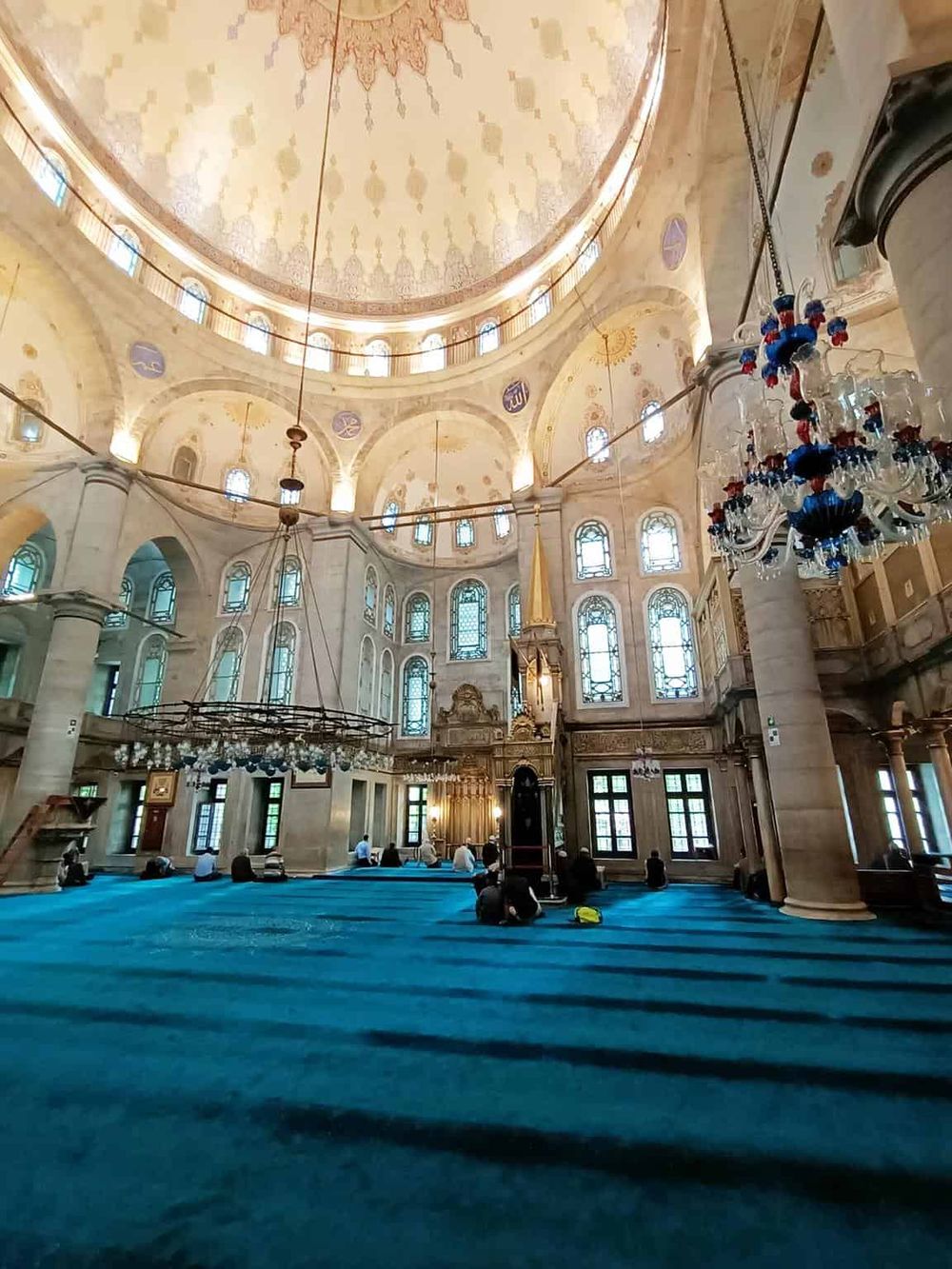 Luxurious mosque interior with ornate architecture and vibrant blue mosque carpet.