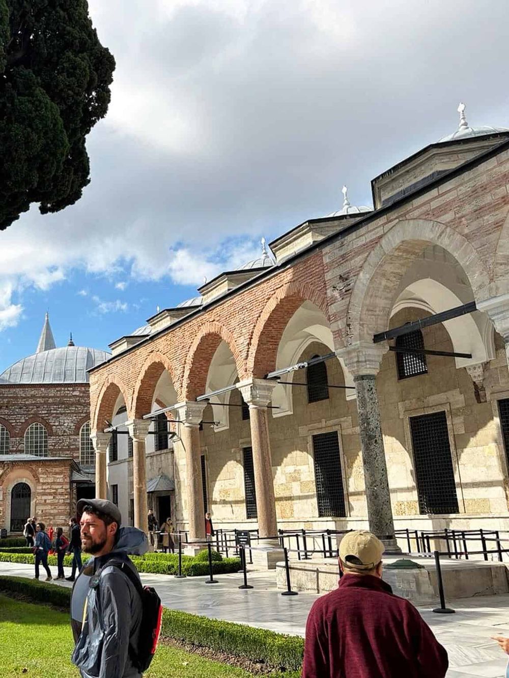 Ancient mosque with arches, domes, and visitors enjoying the historic site in Istanbul, Turkey.