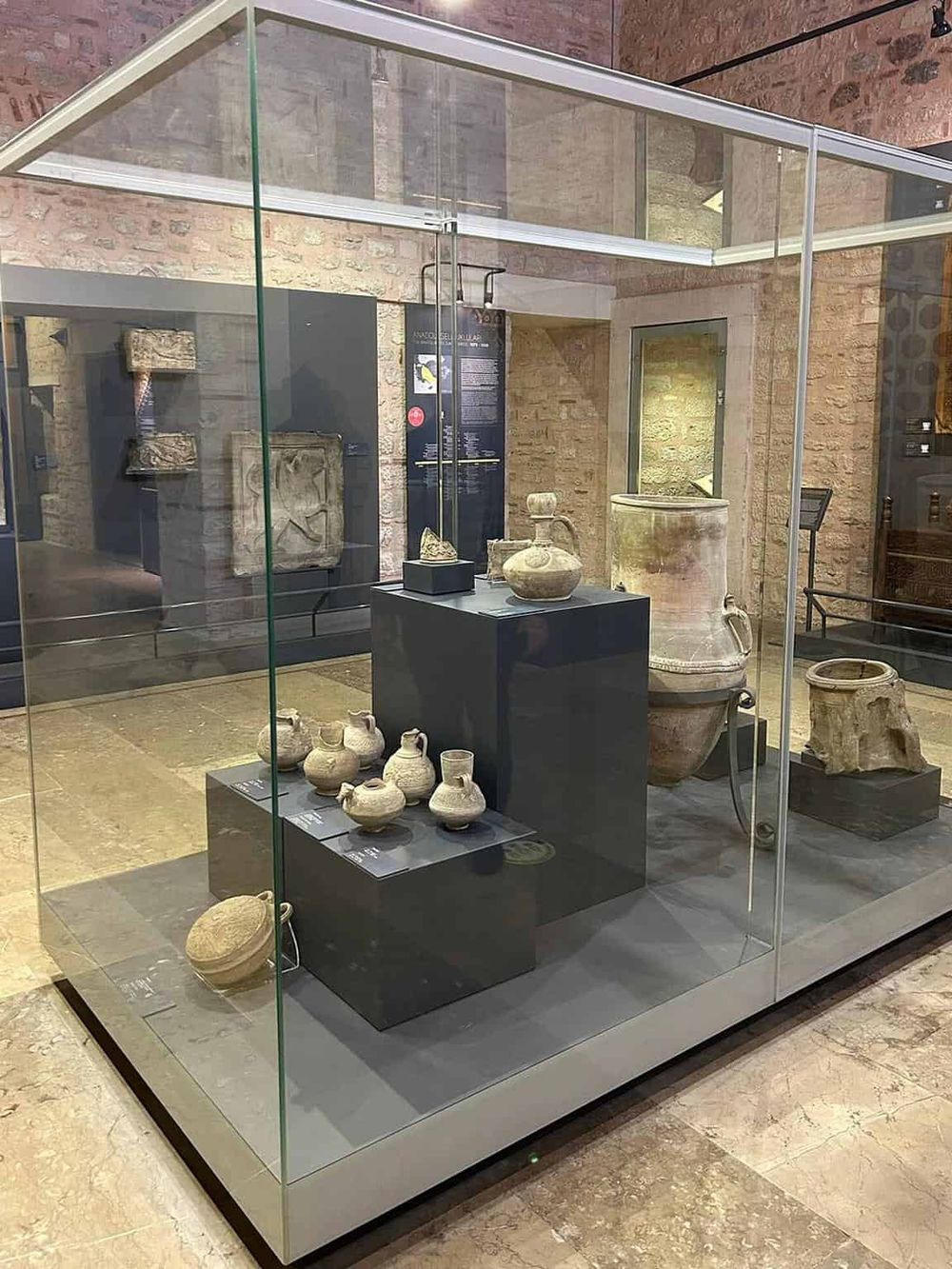 Ancient pottery displayed in a museum glass case showcasing archaeological artifacts.