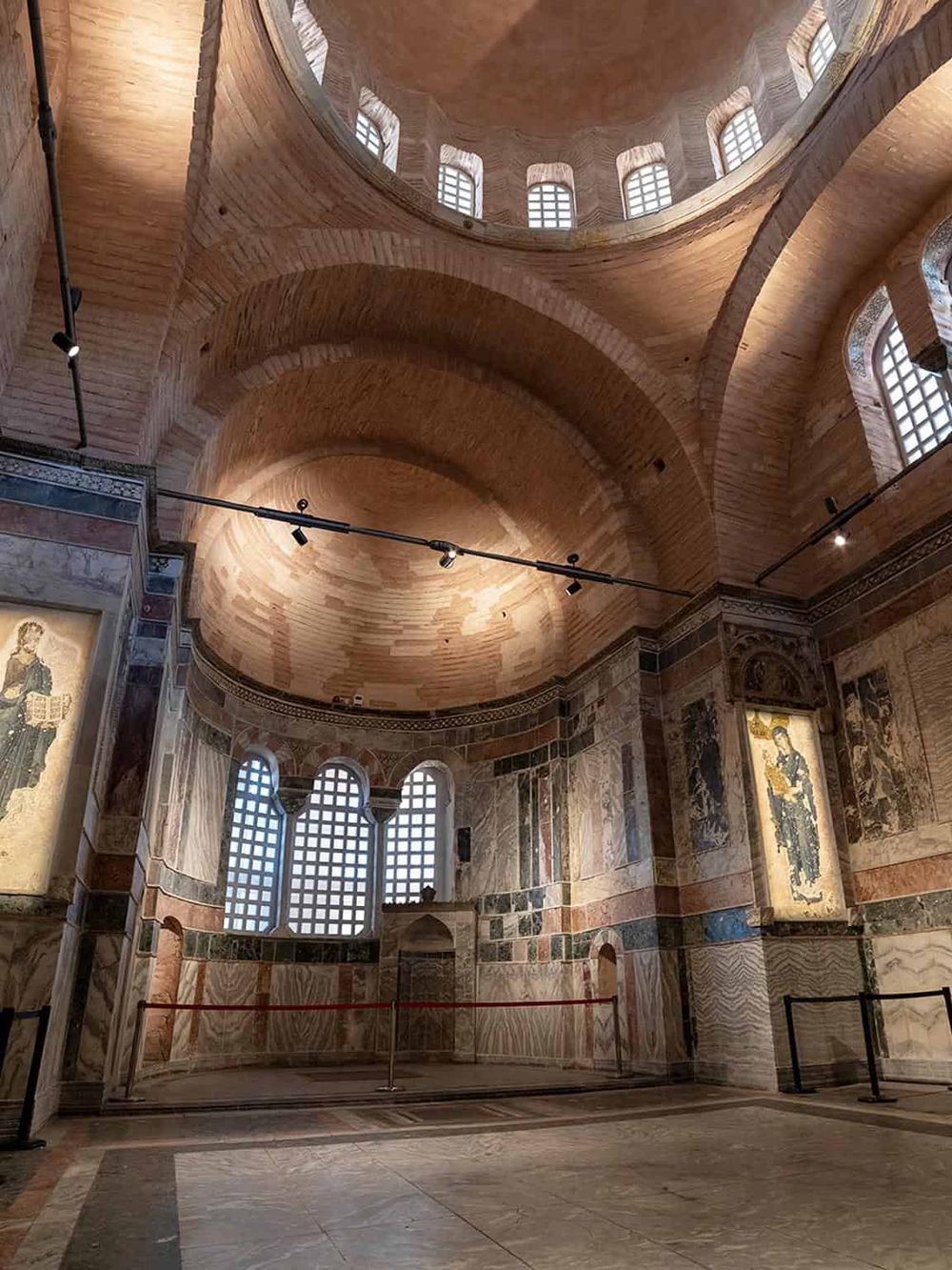 Intricate wooden dome ceiling in a historic church or cathedral with decorative paintings and arched windows.