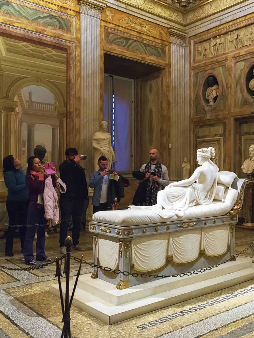 Ancient Roman marble sculpture in museum with visitors, classical art, history, cultural heritage tour.