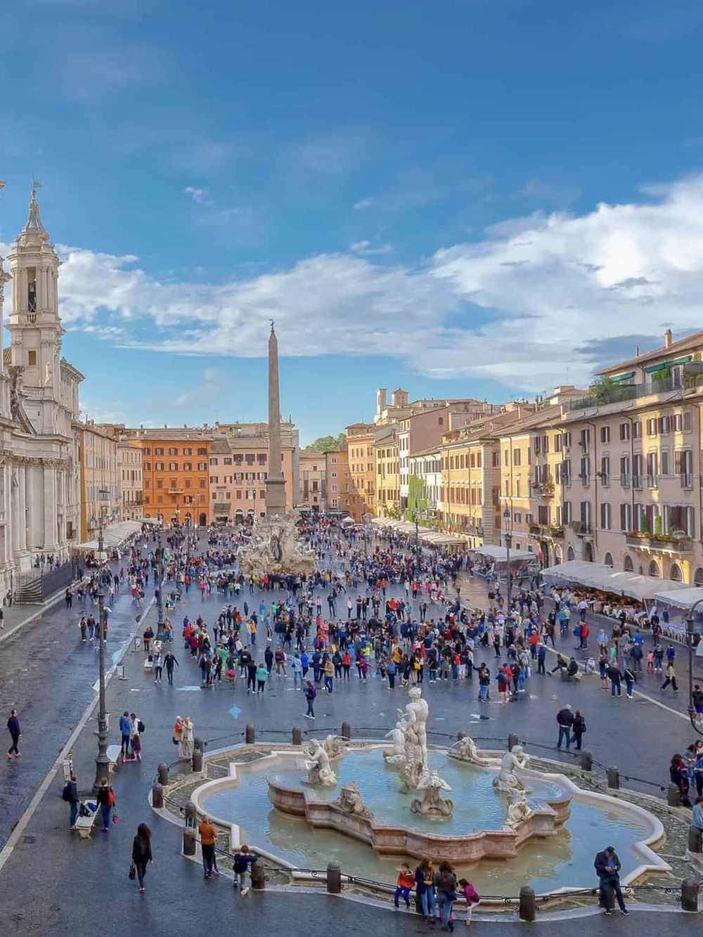 Colorful Piazza Navona in Rome, Italy, bustling with tourists and historic fountains. Explore top travel destinations and city guides.