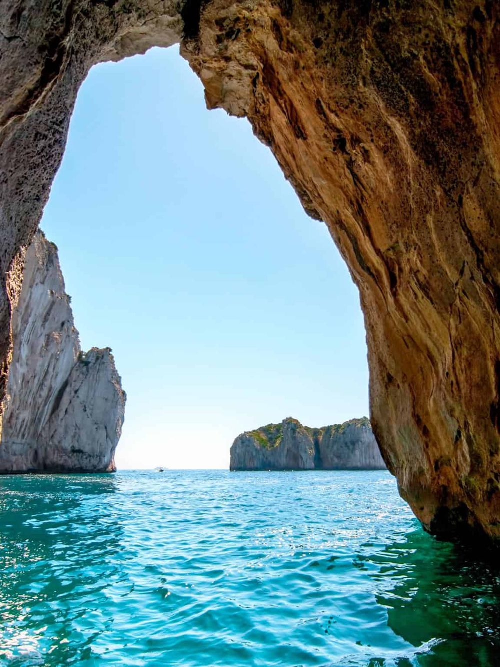 Stunning coastal landscape with rocky cliffs and turquoise waters at a natural sea cave.