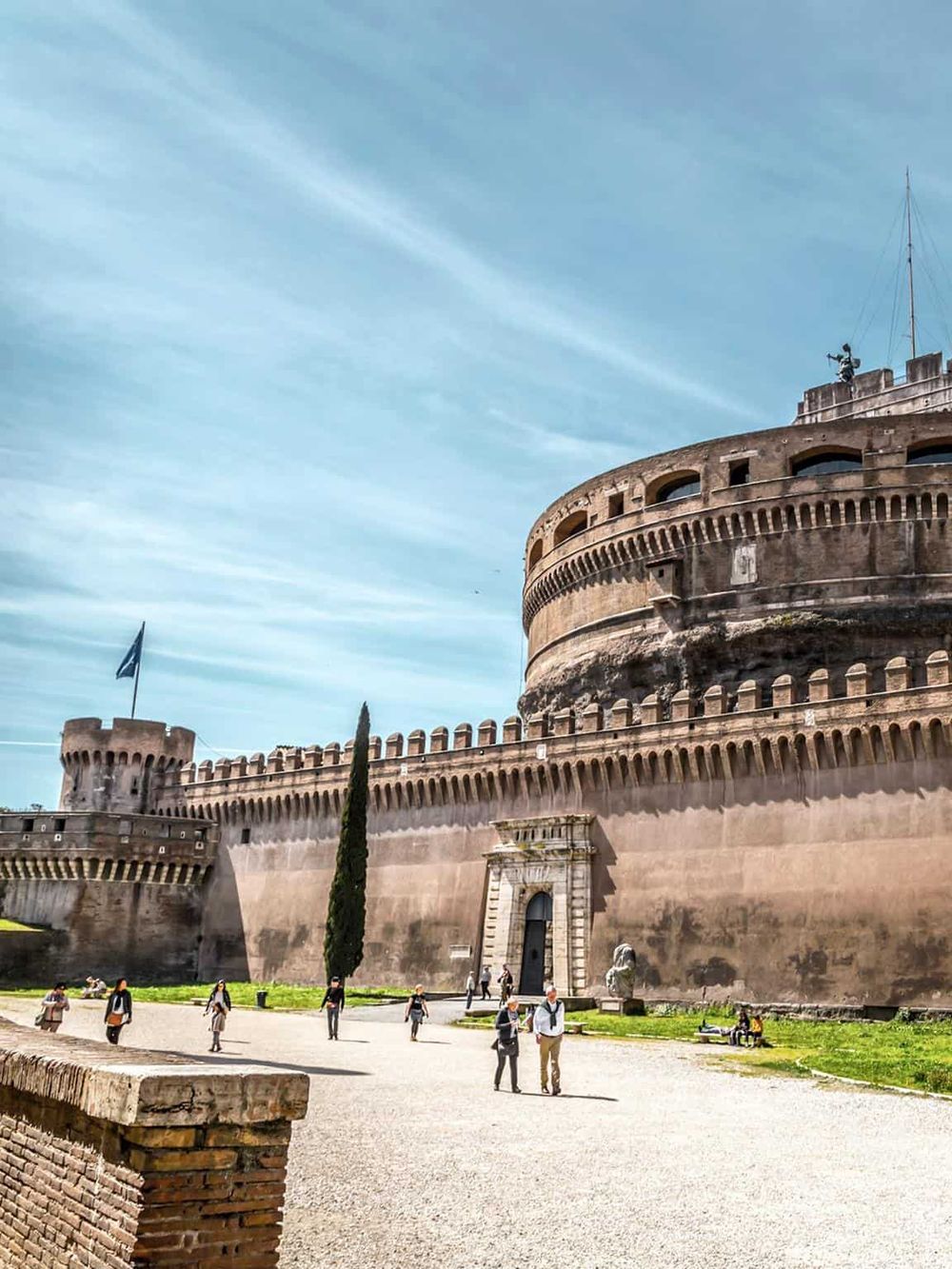 Ancient fortress with historic architecture and tourists exploring Rome's iconic Castel Sant'Angelo.