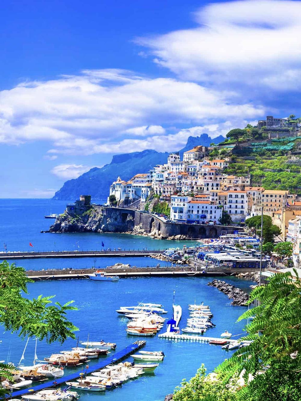 Colorful Amalfi Coast coastal town with boats and hillside buildings, stunning travel destination in Italy.