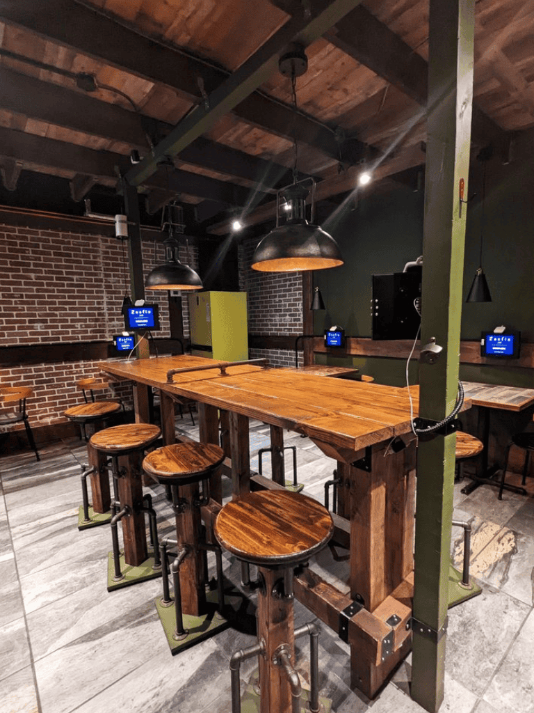 High-top bar table with industrial stools in a modern, cozy indoor space.
