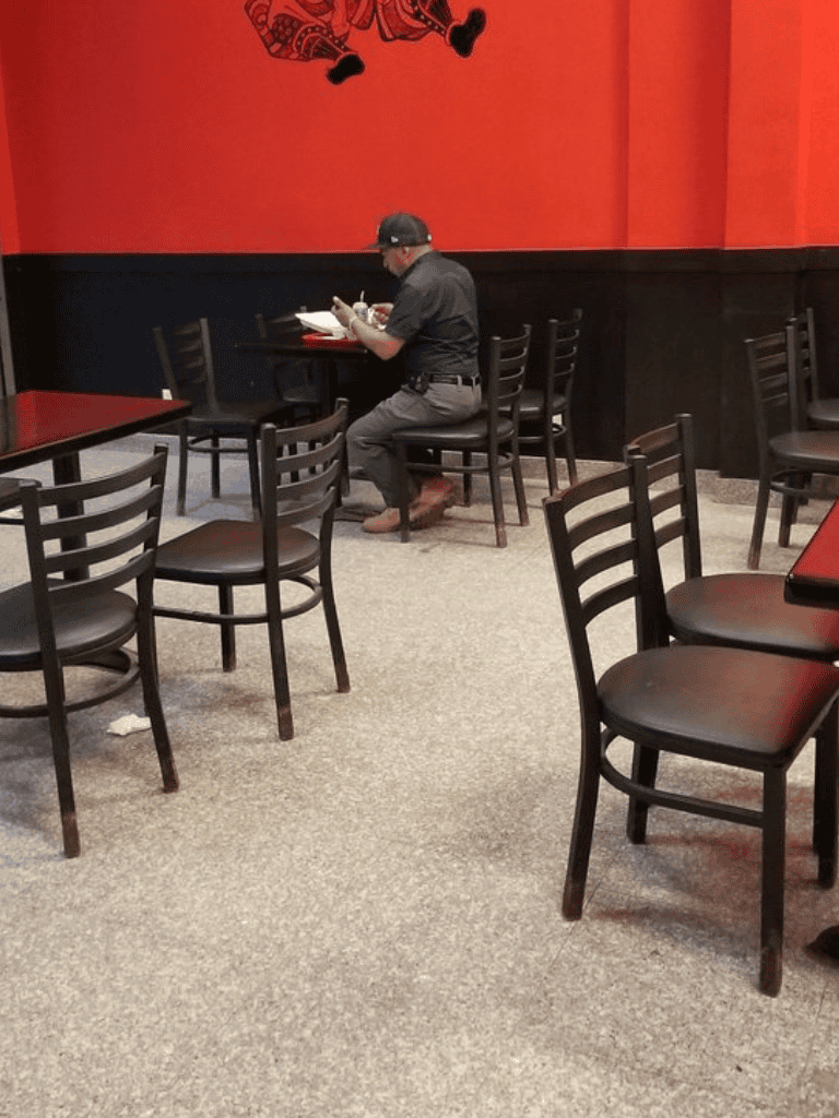 Empty restaurant seating with one person dining alone, casual dining environment, QuestForDirections.